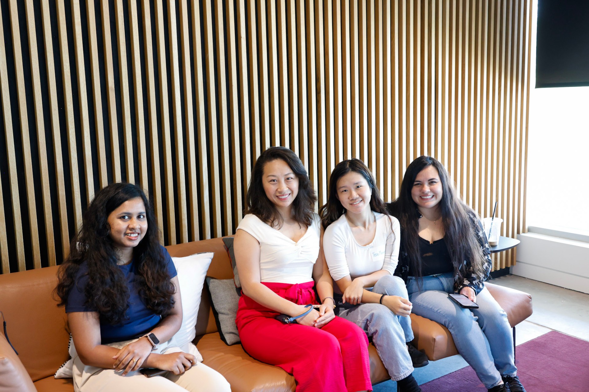 Four attendees smiling on a couch